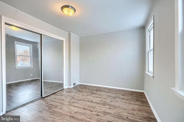 a view of empty room with wooden floor