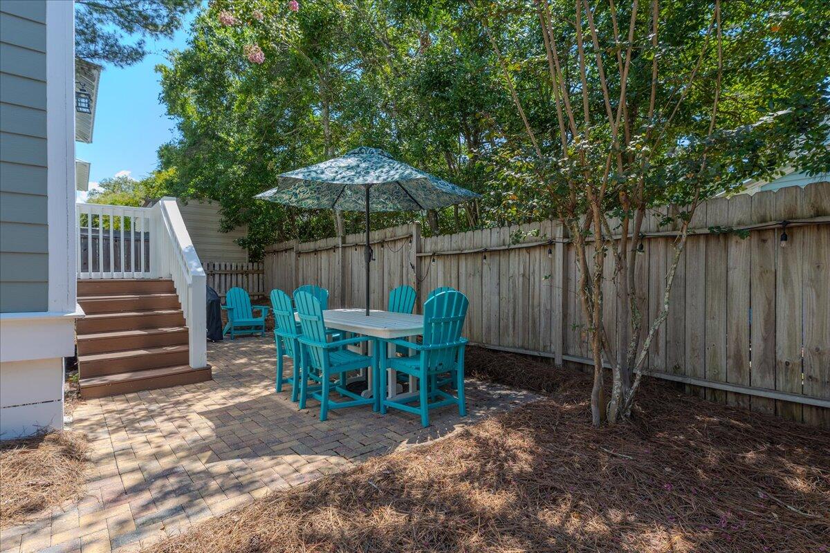 67 Snapper Street Santa Rosa Beach, FL 32459 - Photo 40 of 48 a view of backyard with table and chairs under an umbrella with wooden fence