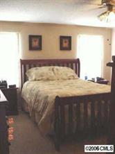 338 Tirzah Church Road Lancaster, SC 29720 - Photo 6 of 8 a bed sitting in a bedroom next to a window