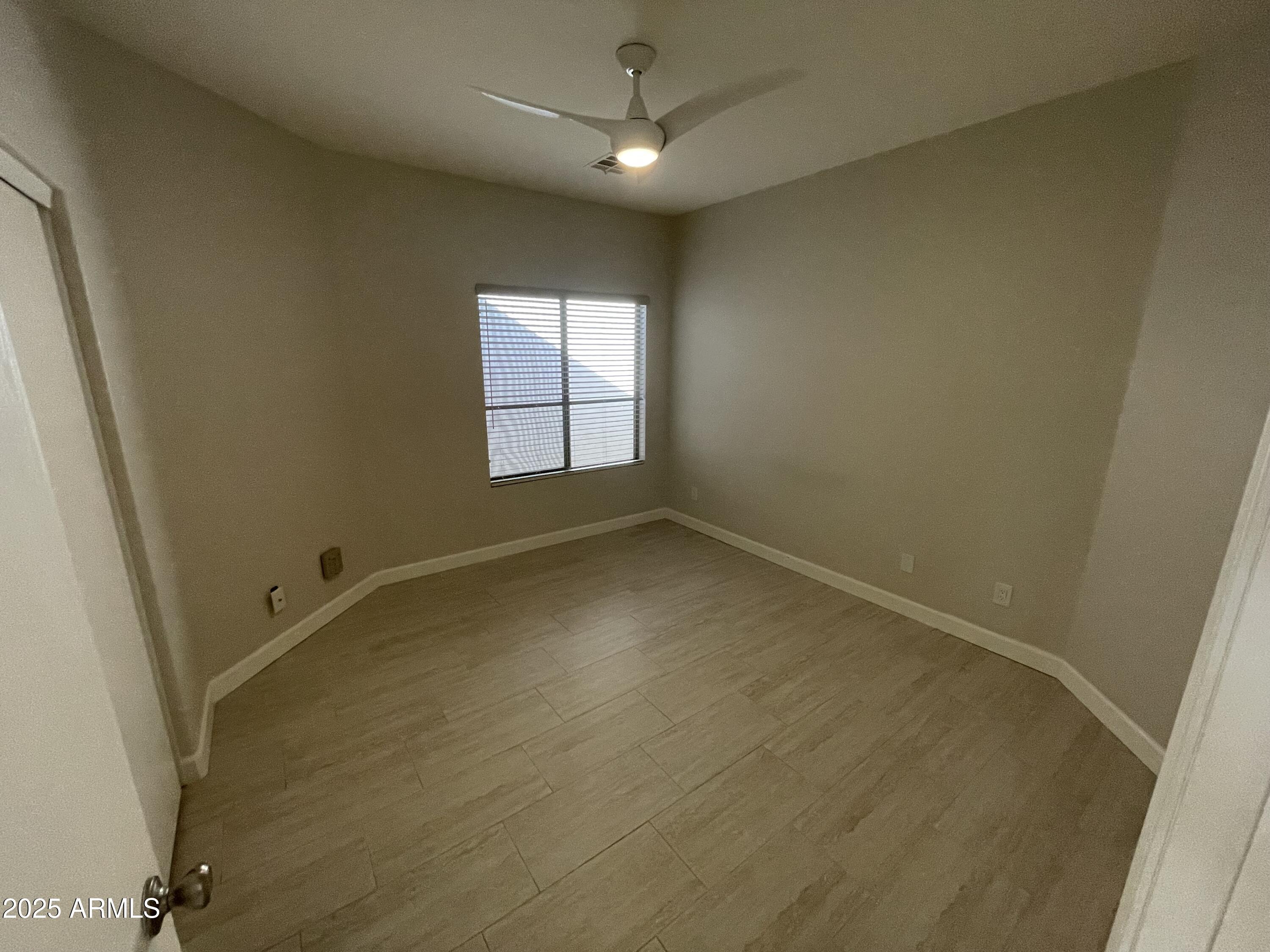 3803 West Commonwealth Avenue Chandler, AZ 85226 - Photo 7 of 15 an empty room with windows and ceiling fan
