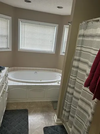a bathroom with a bathtub and next to a window