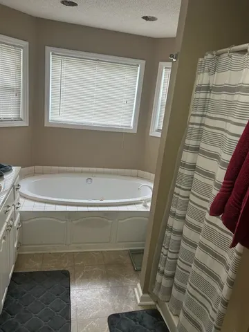 a bathroom with a bathtub and next to a window