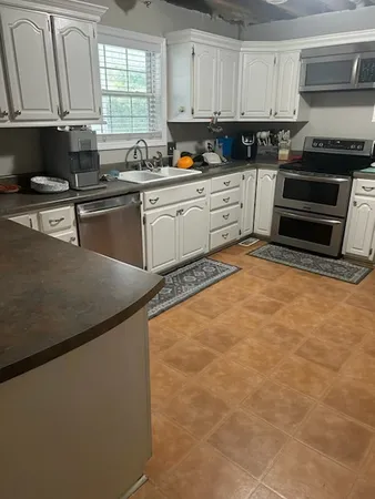 a kitchen with stainless steel appliances granite countertop a sink stove and cabinets