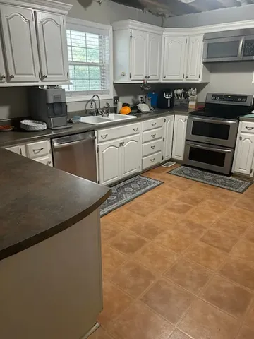 a kitchen with stainless steel appliances granite countertop a sink stove and cabinets
