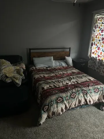 a bed sitting in a bedroom next to a window