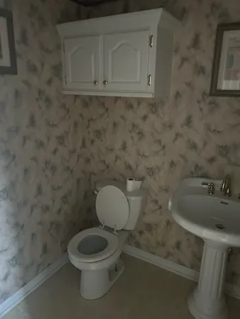 a bathroom with a toilet sink and mirror