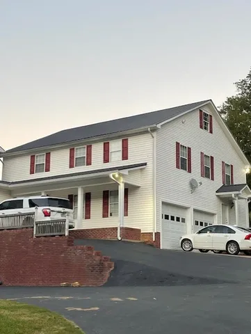 a view of a white house in front of a big yard