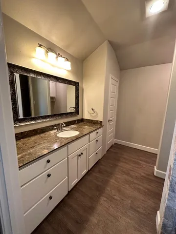 a bathroom with granite countertop double vanity and a mirror