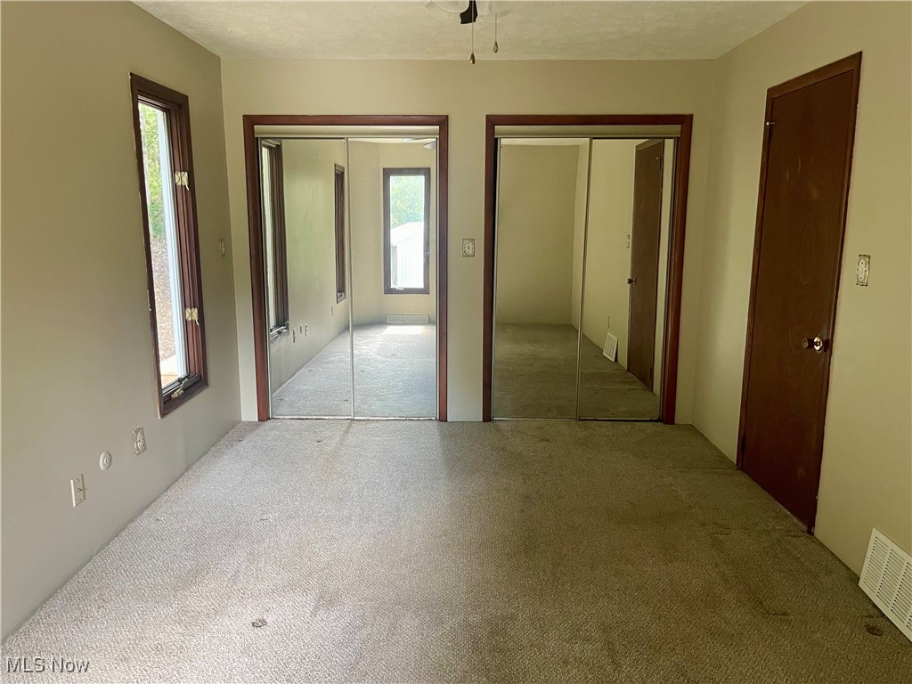 6518 Stonecreek Road Southwest Newcomerstown, OH 43832 - Photo 16 of 42 Bedroom on the first floor with two closets and a ceiling fan.