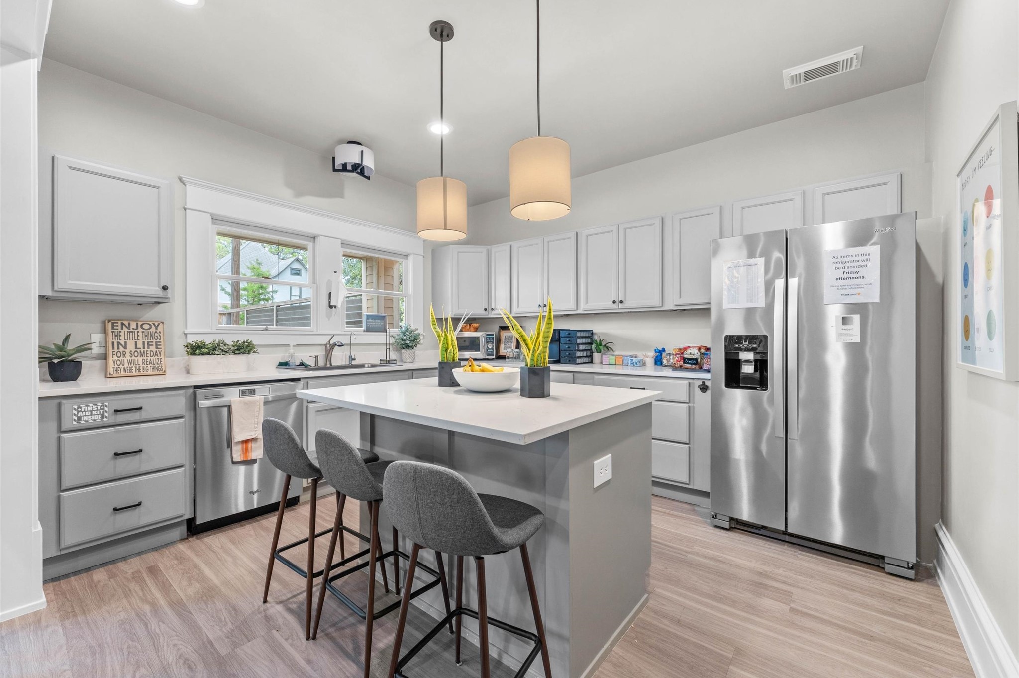 945 Harvard Street Houston, TX 77008 - Photo 25 of 47 a kitchen with stainless steel appliances granite countertop a refrigerator a sink dishwasher a stove and white cabinets with wooden floor