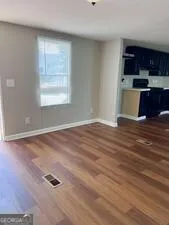 an empty room with wooden floor and window