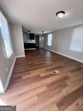 a view of empty room with wooden floor