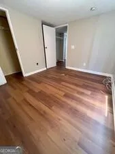 a view of empty room with wooden floor