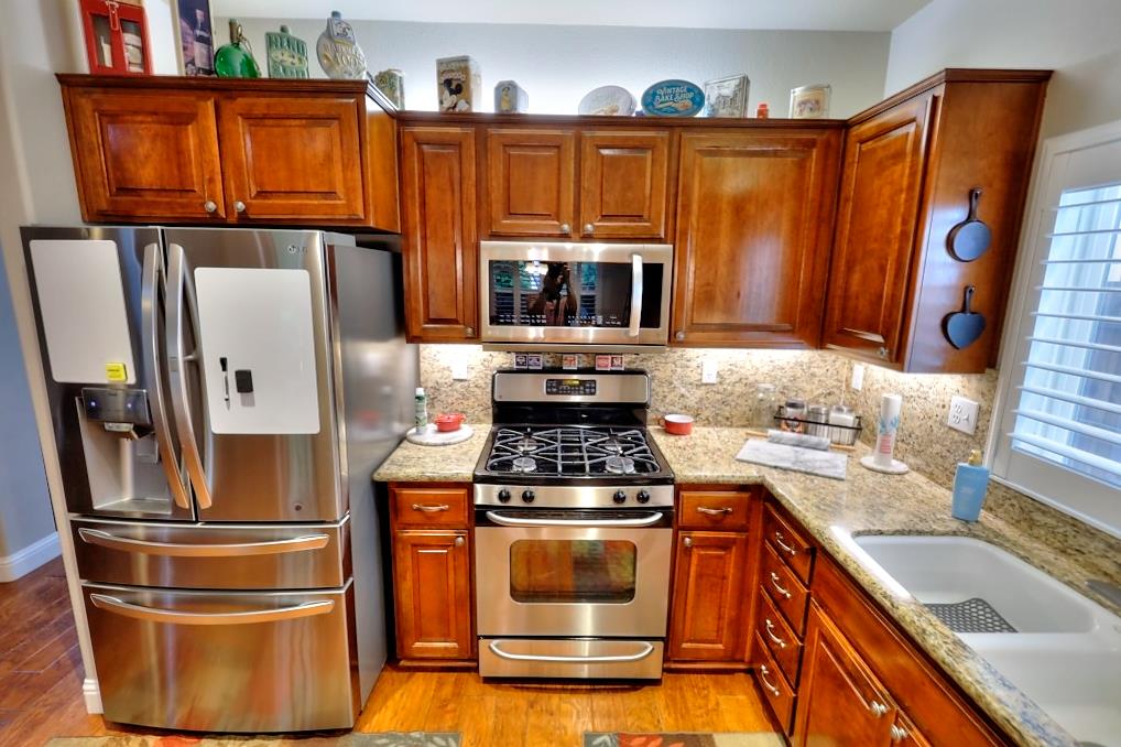 4152 Post Oak Drive Turlock, CA 95382 - Photo 29 of 71 a kitchen with granite countertop a refrigerator stove and washer