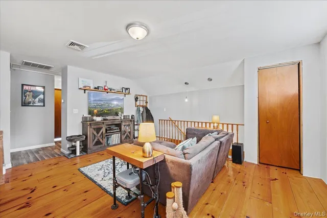 a living room with furniture kitchen view and a large window