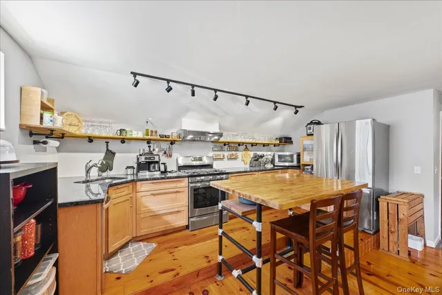 a kitchen with stainless steel appliances granite countertop a refrigerator and microwave