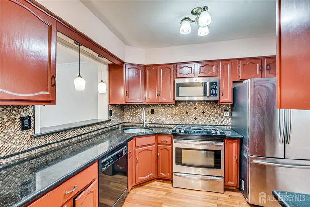 a kitchen with stainless steel appliances granite countertop a refrigerator stove and sink