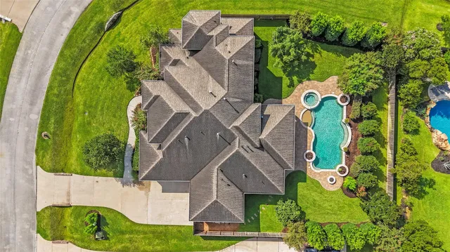 an aerial view of a house with swimming pool and garden
