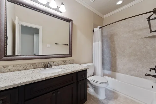 a bathroom with a granite countertop sink toilet a mirror and shower