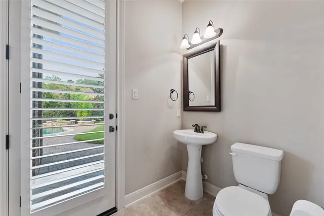 a bathroom with a toilet a sink and mirror