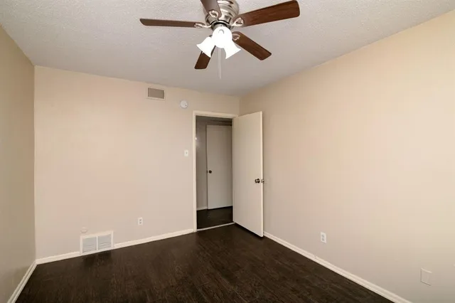 an empty room with closet and a chandelier fan