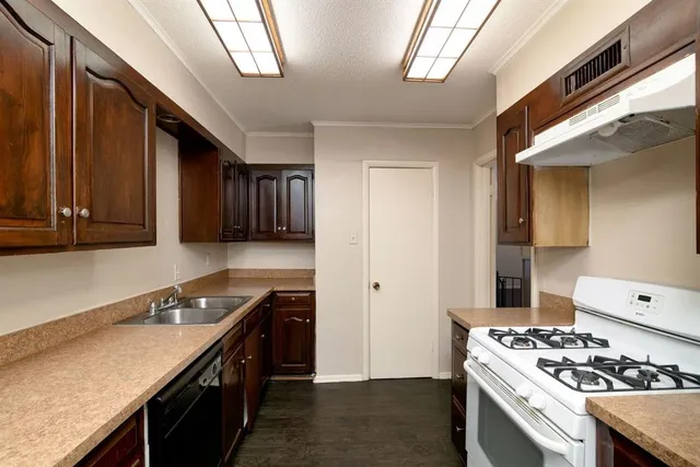 a kitchen with stainless steel appliances granite countertop a stove a sink dishwasher and a refrigerator