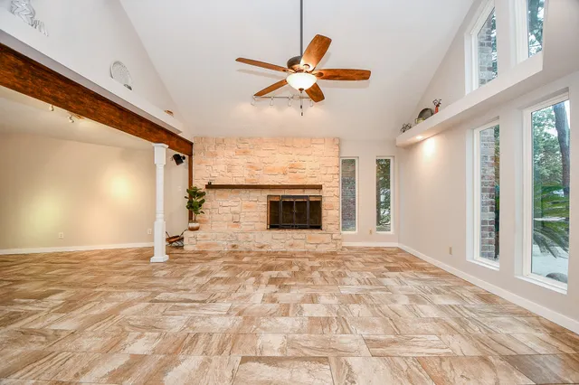 a view of empty room with fireplace and fan