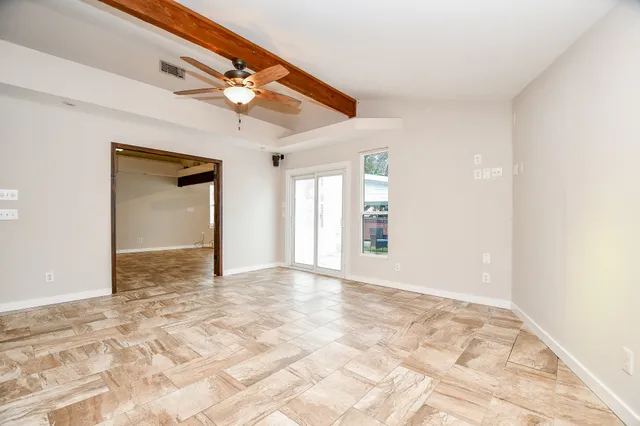 a view of a hallway with wooden floor and windows