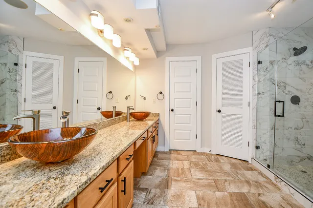 a bathroom with a granite countertop sink mirror and shower