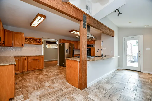 a kitchen with stainless steel appliances granite countertop a refrigerator and a sink