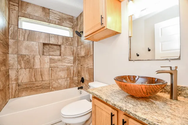 an empty room with a ceiling fan and window