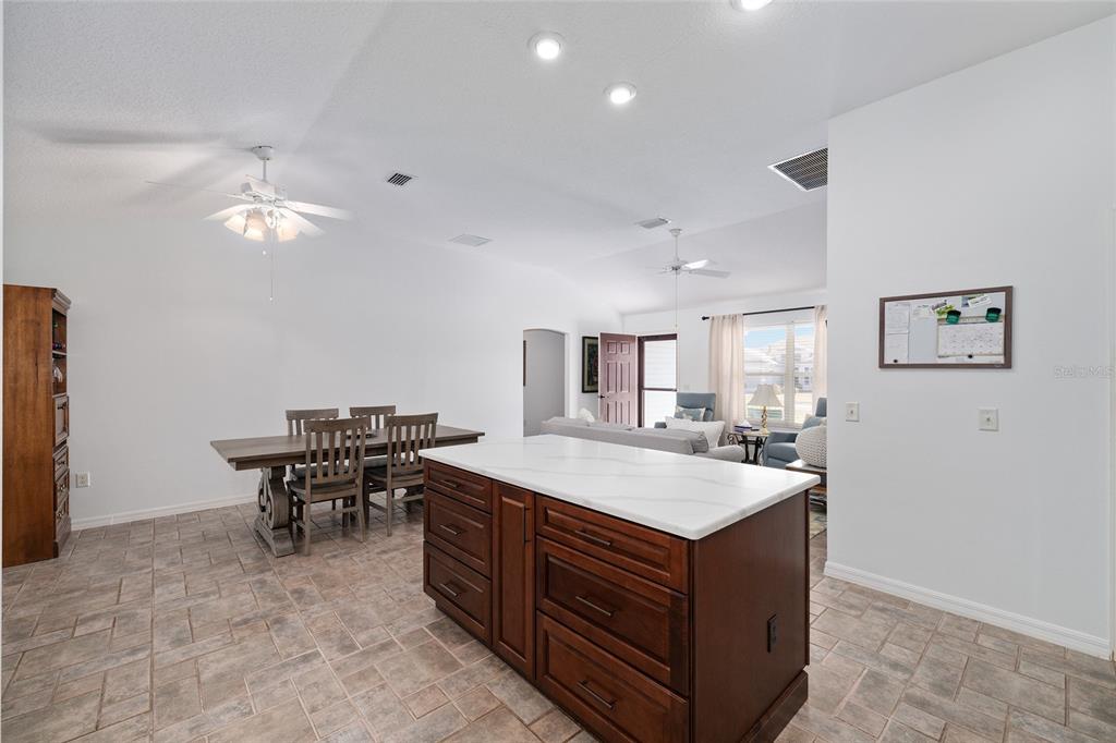 3073 Riverdale Road The Villages, FL 32162 - Photo 11 of 38 a room with a chandelier a dining table and chairs