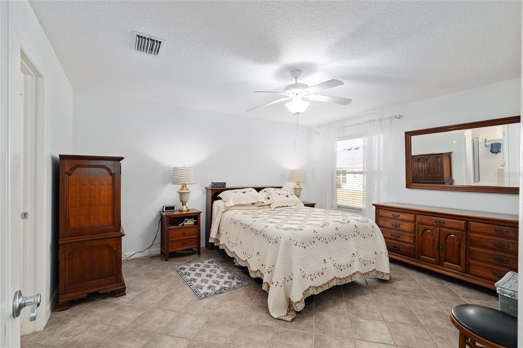 3073 Riverdale Road The Villages, FL 32162 - Photo 15 of 38 a bedroom with a bed and a chandelier
