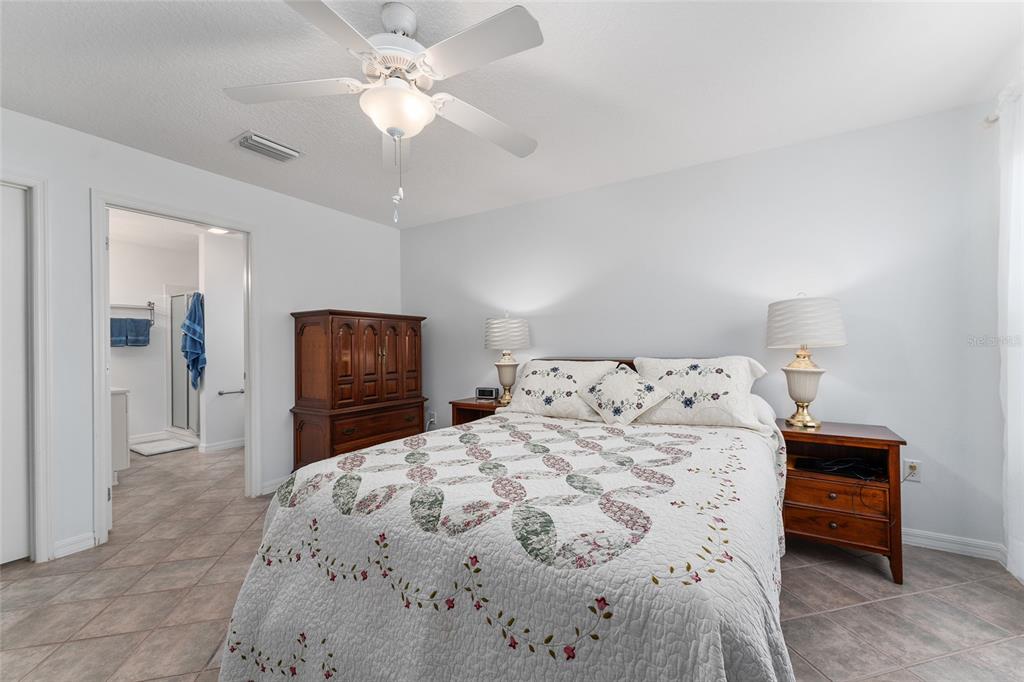 3073 Riverdale Road The Villages, FL 32162 - Photo 16 of 38 a bedroom with a bed and a chandelier