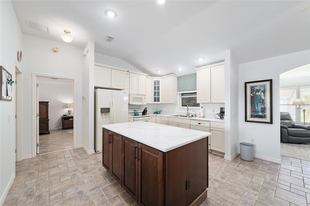 3073 Riverdale Road The Villages, FL 32162 - Photo 8 of 38 a large kitchen with stainless steel appliances a sink stove refrigerator and cabinets