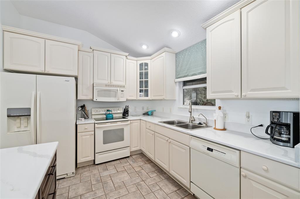 3073 Riverdale Road The Villages, FL 32162 - Photo 10 of 38 a kitchen with cabinets appliances a sink and a counter top space