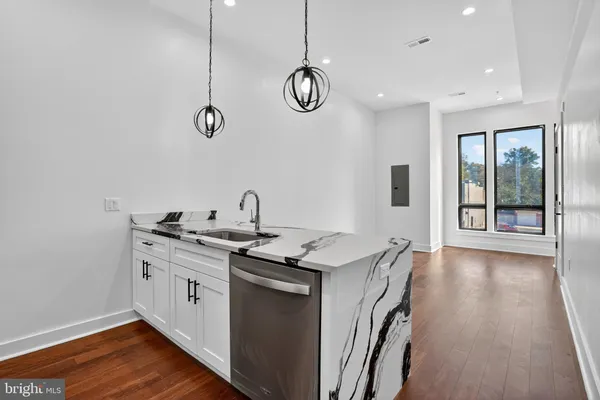 a view of a living room and kitchen with stainless steel appliances wooden floor