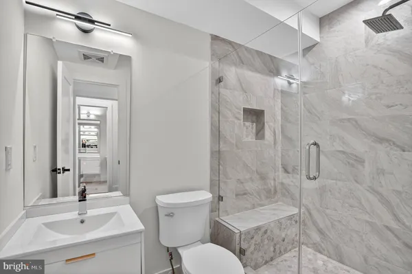 a view of kitchen with stainless steel appliances refrigerator stove microwave and wooden floor