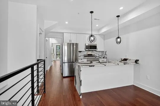 a kitchen that has a lot of cabinets and wooden floor