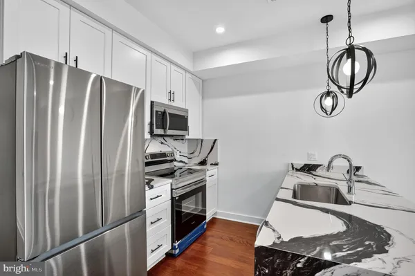 a kitchen with stainless steel appliances a refrigerator stove and microwave