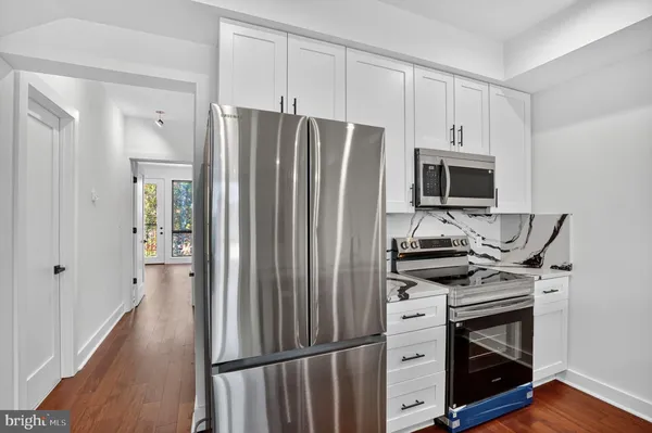 an empty room with mirror and a wooden floor