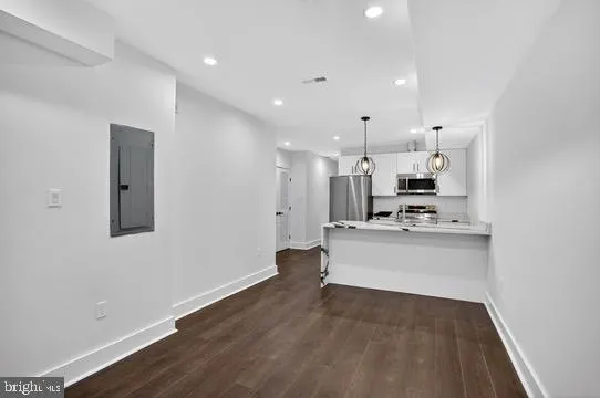 a kitchen with stainless steel appliances granite countertop a sink a stove and wooden floor