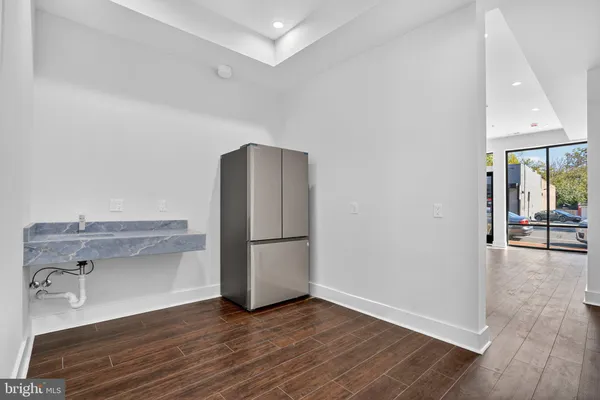 a view of a kitchen with wooden floor and a refrigerator