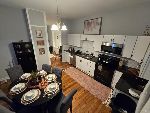 a kitchen with a sink dishwasher a stove and a refrigerator with wooden floor