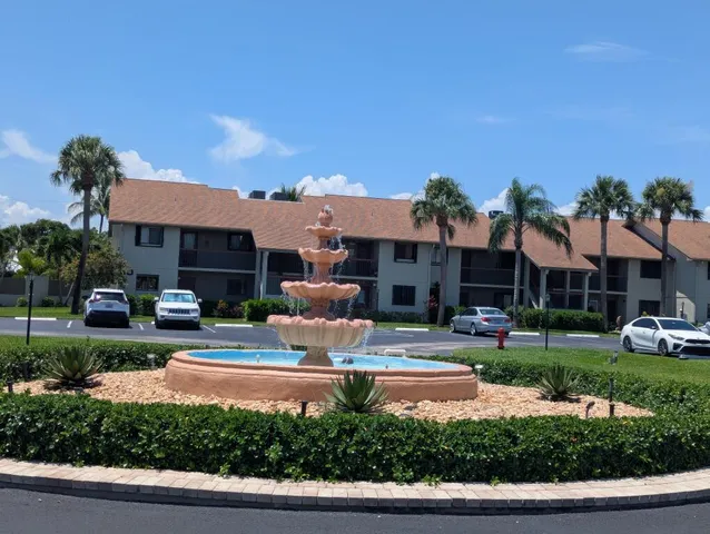 a front view of a house with a yard and potted plants