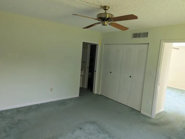 an empty room with a ceiling fan and a window