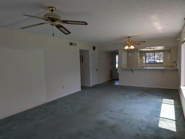 en empty room with windows and ceiling fan