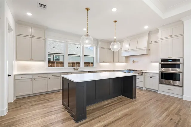 a large kitchen with stainless steel appliances kitchen island granite countertop a sink and cabinets
