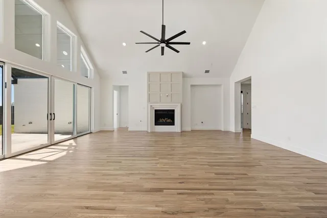 a view of a livingroom with a ceiling fan window and wooden floor