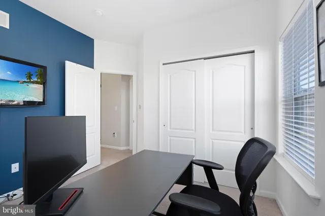 a view of a workspace with furniture and a window